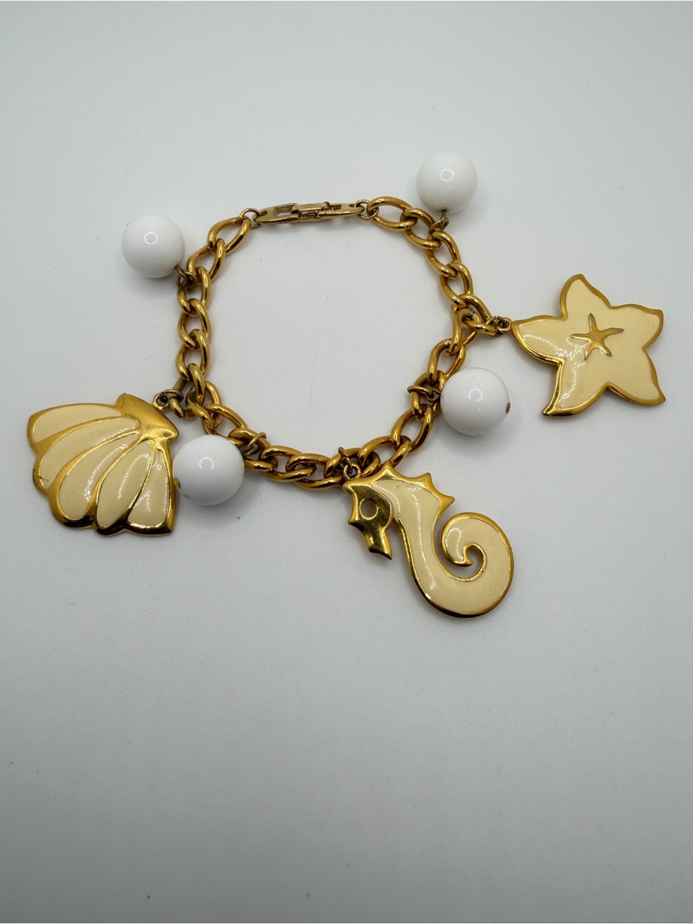 8" Vintage signed Napier Beige Coastal Sea Charm Bracelet in Gold tone metal!
